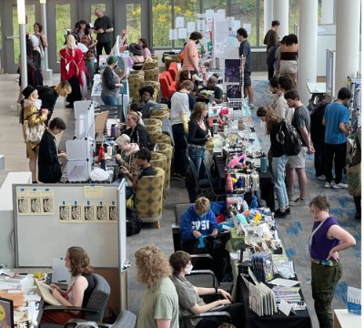 lined up artist booths with shoppers looking at products and talking with artists.